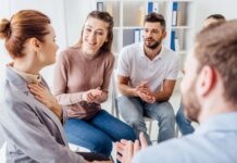 Videreutdanning i Åpen dialog i nettverk og dialogiske praksiser En gruppe mennekser som sitter i sirkel og snakker sammen.