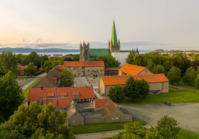 Foto av Erkebispegården med Nidarosdomen og Trondheimsfjorden i bakgrunnen